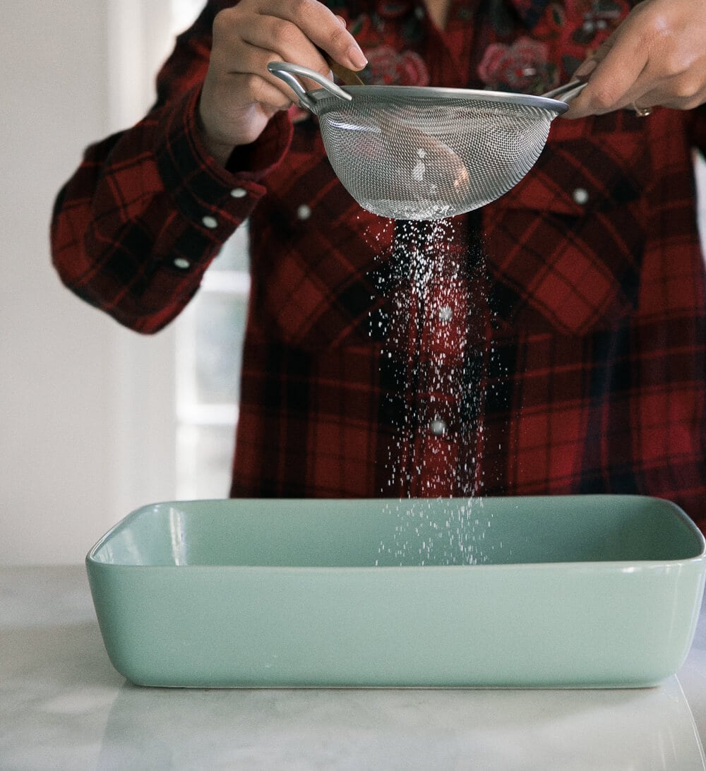 Dusting the baking dish. 