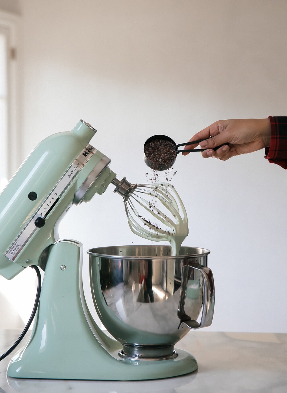 Cacao nibs being added to a stand-up mixer. 