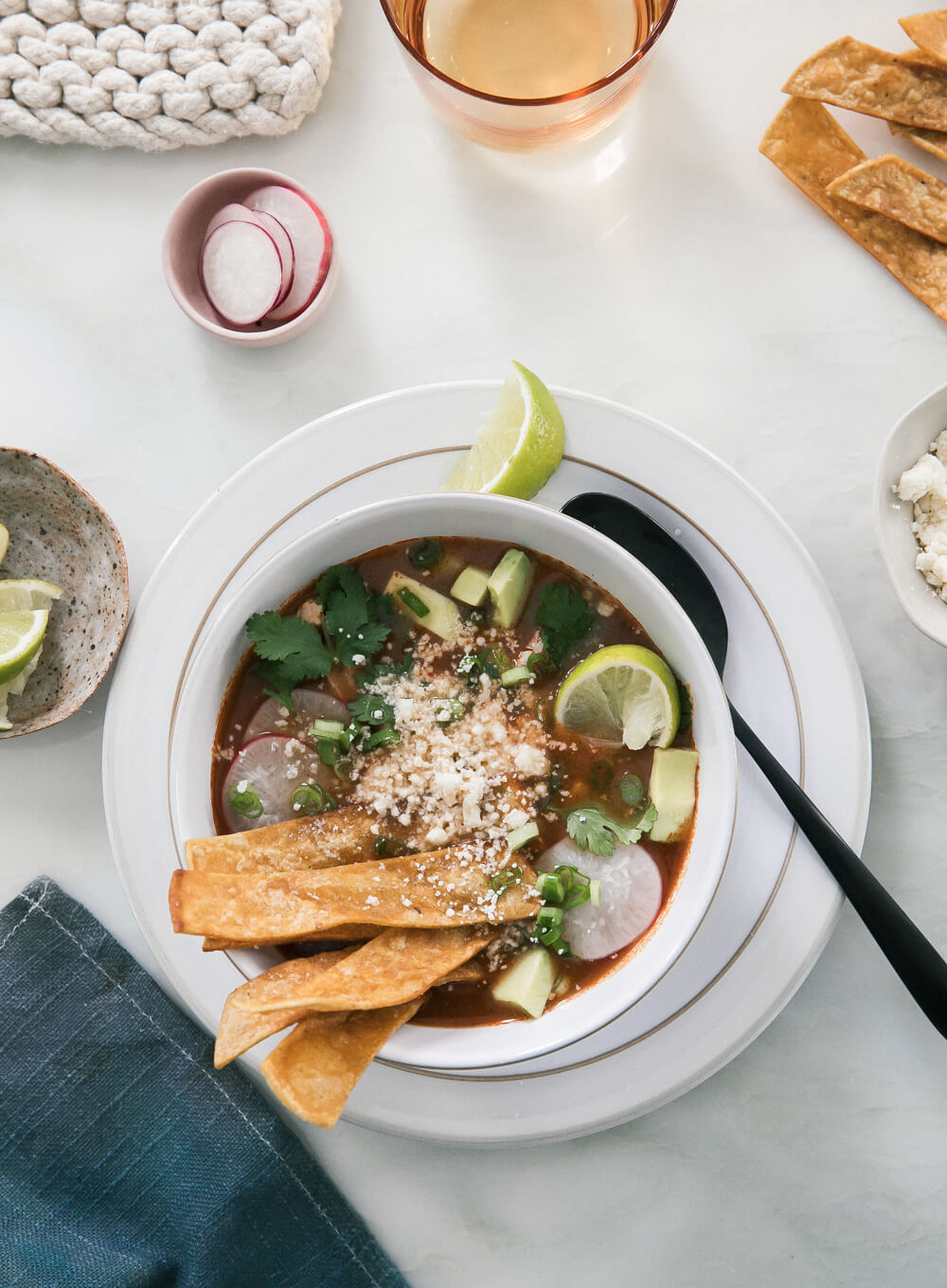 Overhead image of enchilada chicken soup in a bowl loaded with topping. 