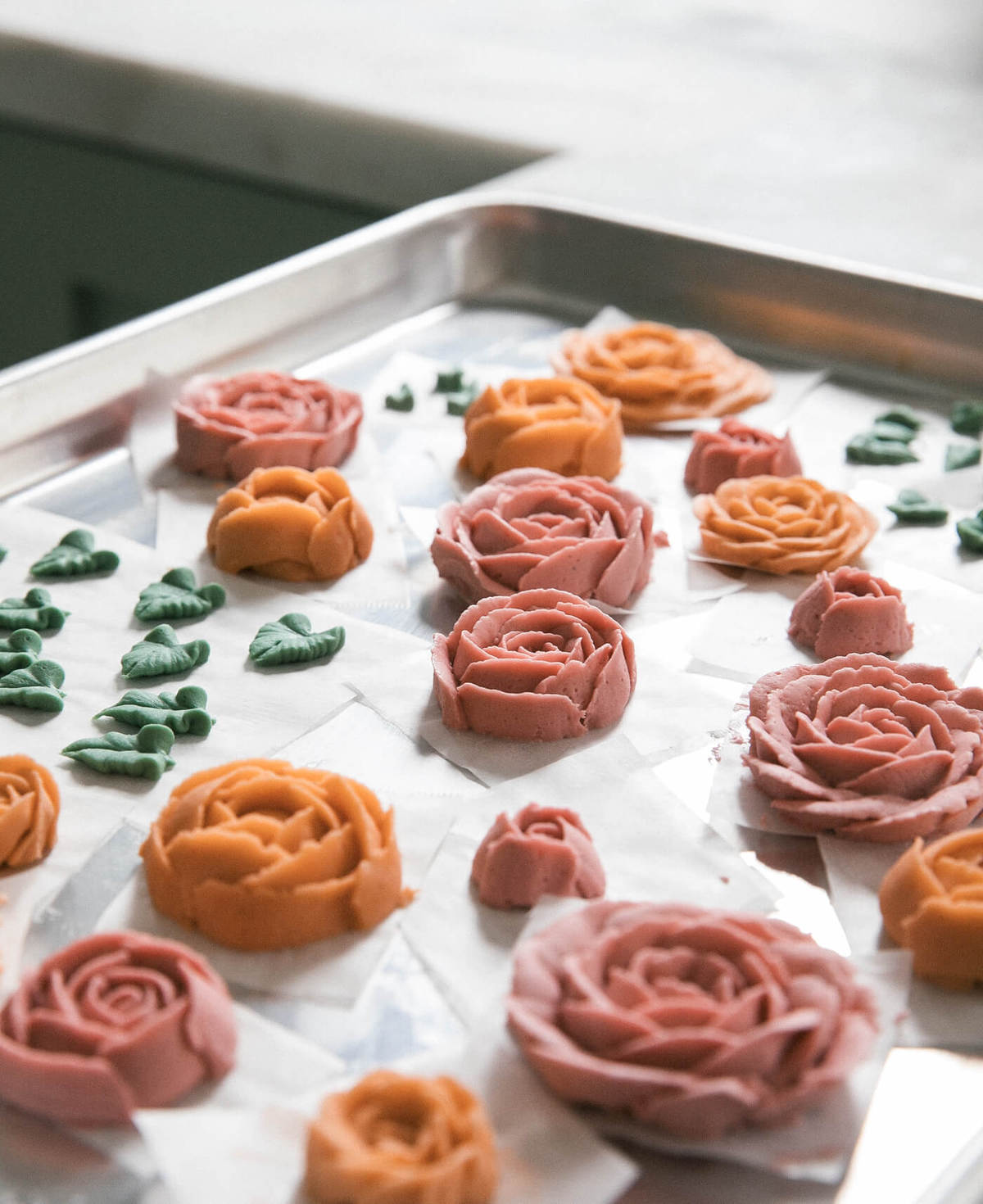 Buttercream flowers on baking sheet. 