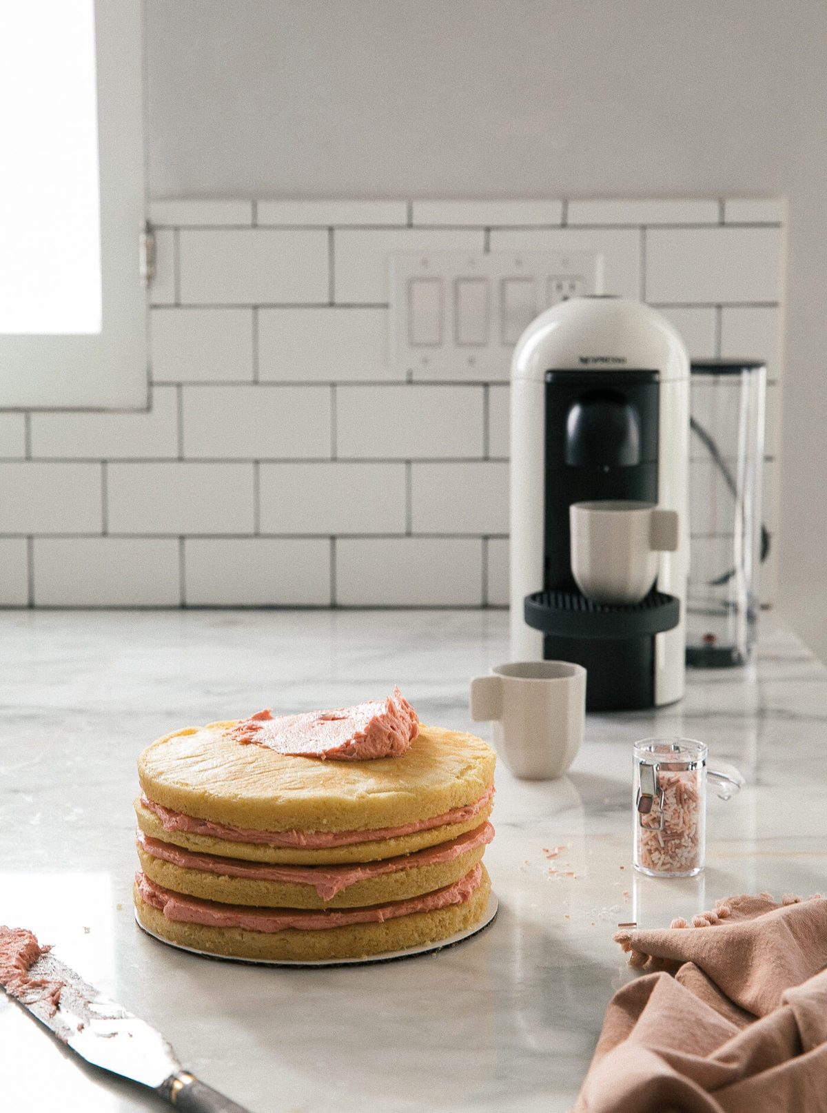 Process shot of cake being frosted with buttercream.