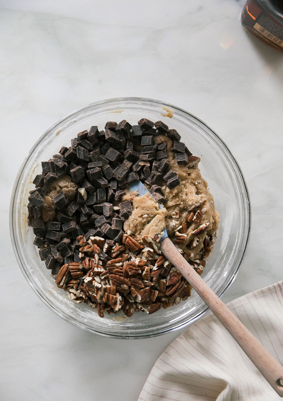 Cookie dough in a bowl with chocolate chunks and pecans. 