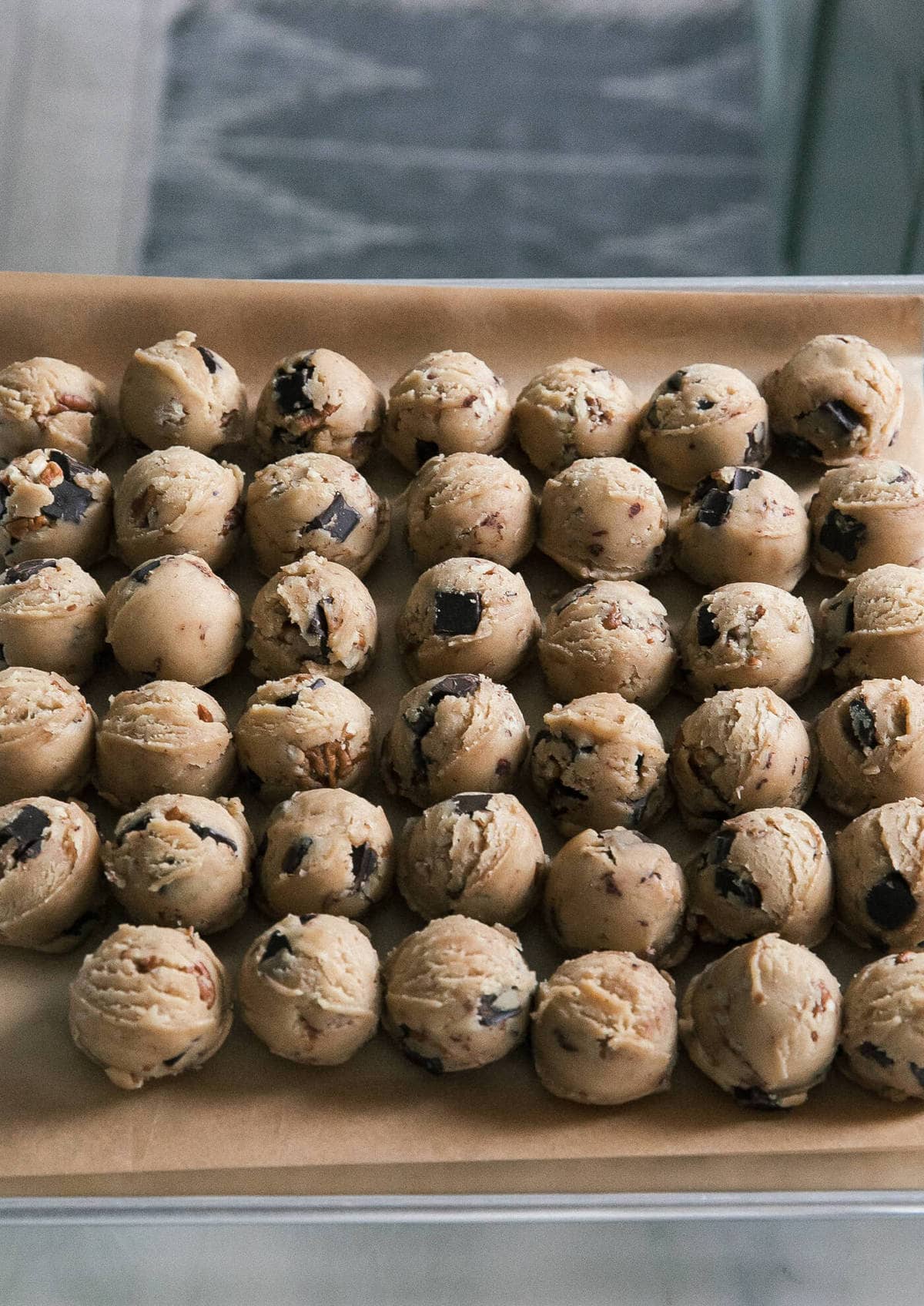 Balls of cookie dough on a sheet pan.