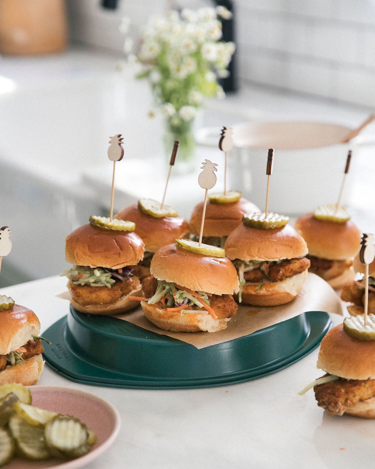 Baked Nashville Hot Chicken Sandwiches with skewers in the tops of the sandwiches. 