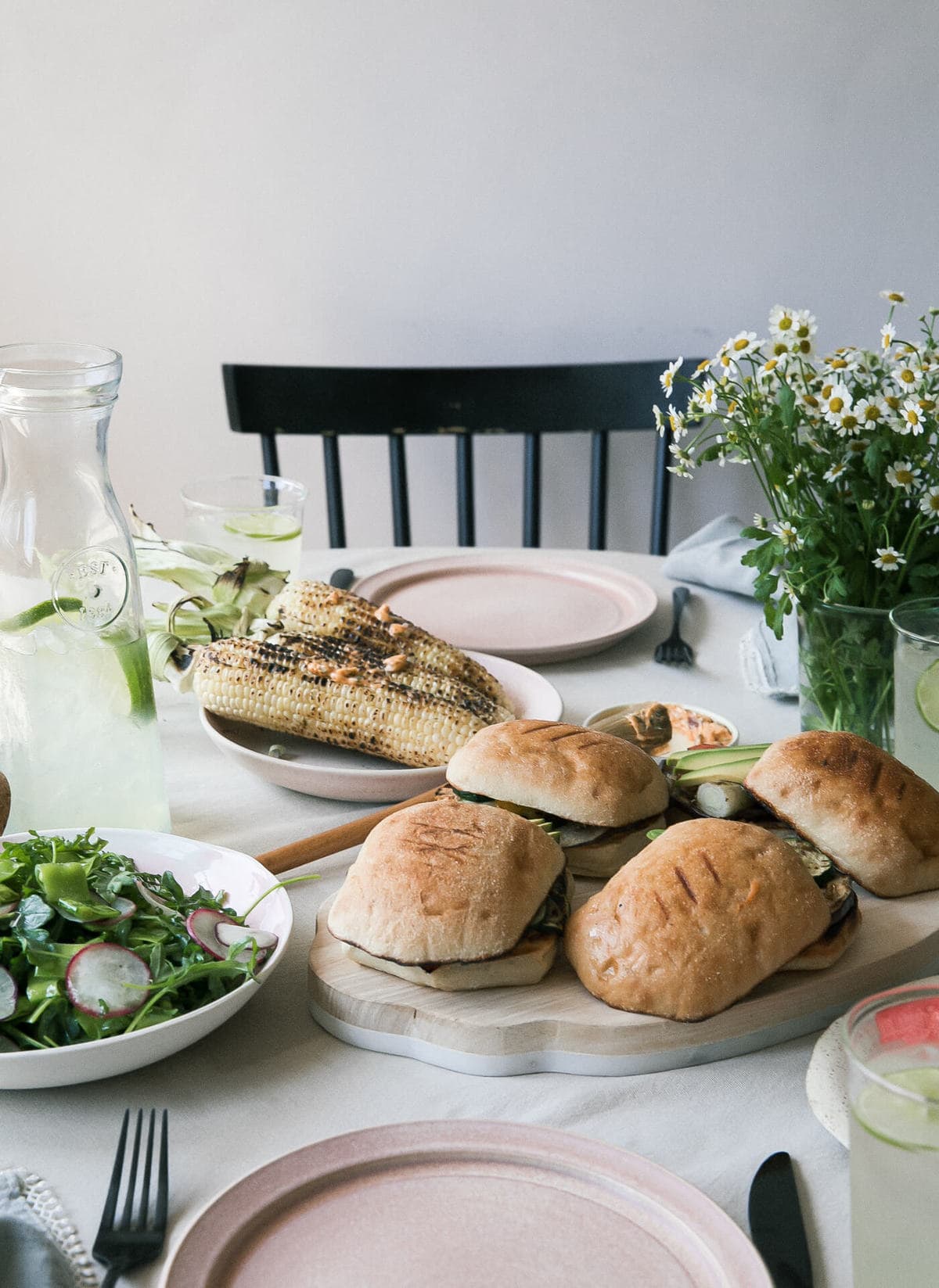 Grilled Veggie Sandwiches on table with an array of foods. 