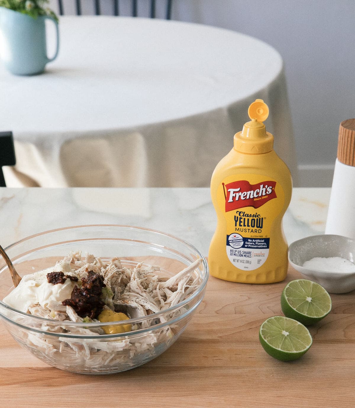 Chicken being mixed with mayonnaise, chipotle, mustard and lime. 