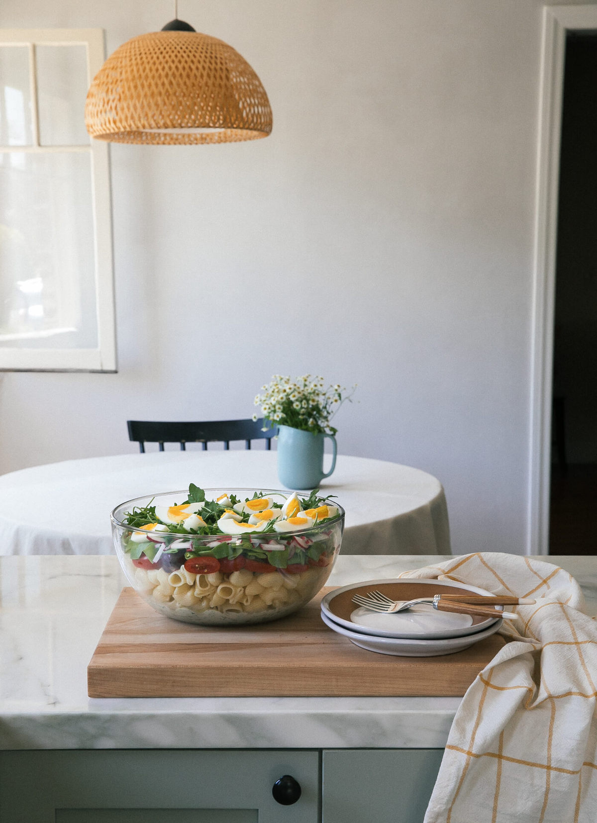 Seven Layer Pasta Salad in serving bowl on cutting board. 