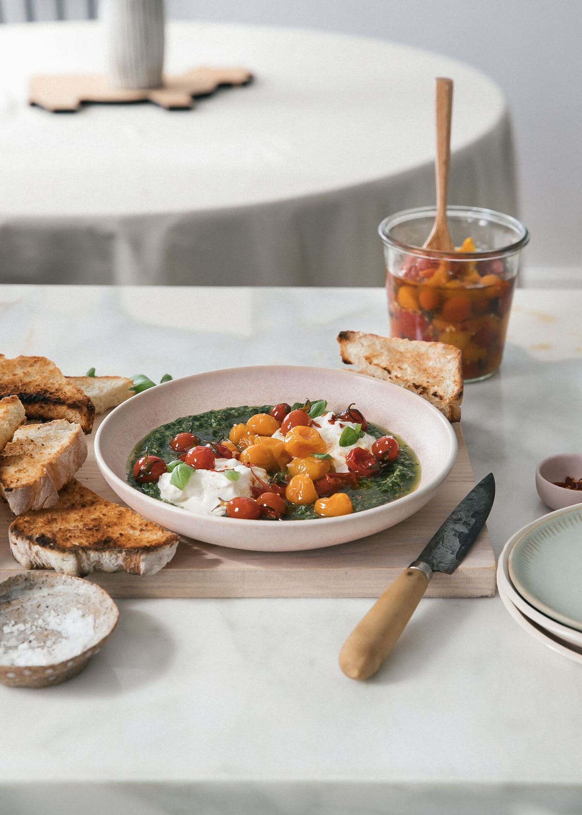 Tomato Confit in bowl with burrata and pesto. 