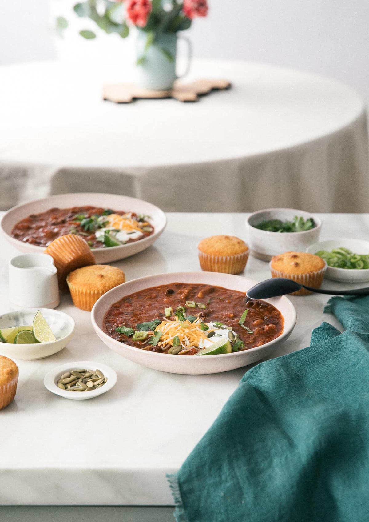 Pumpkin Chili on counter with garnishes and cornbread. 