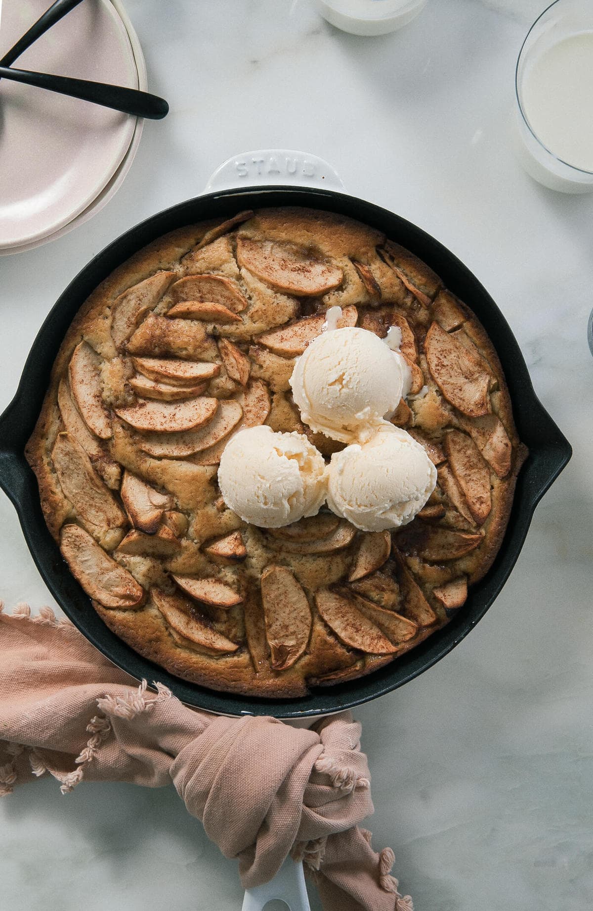 Chai Apple Skillet Cake in a pan with ice cream on top. 