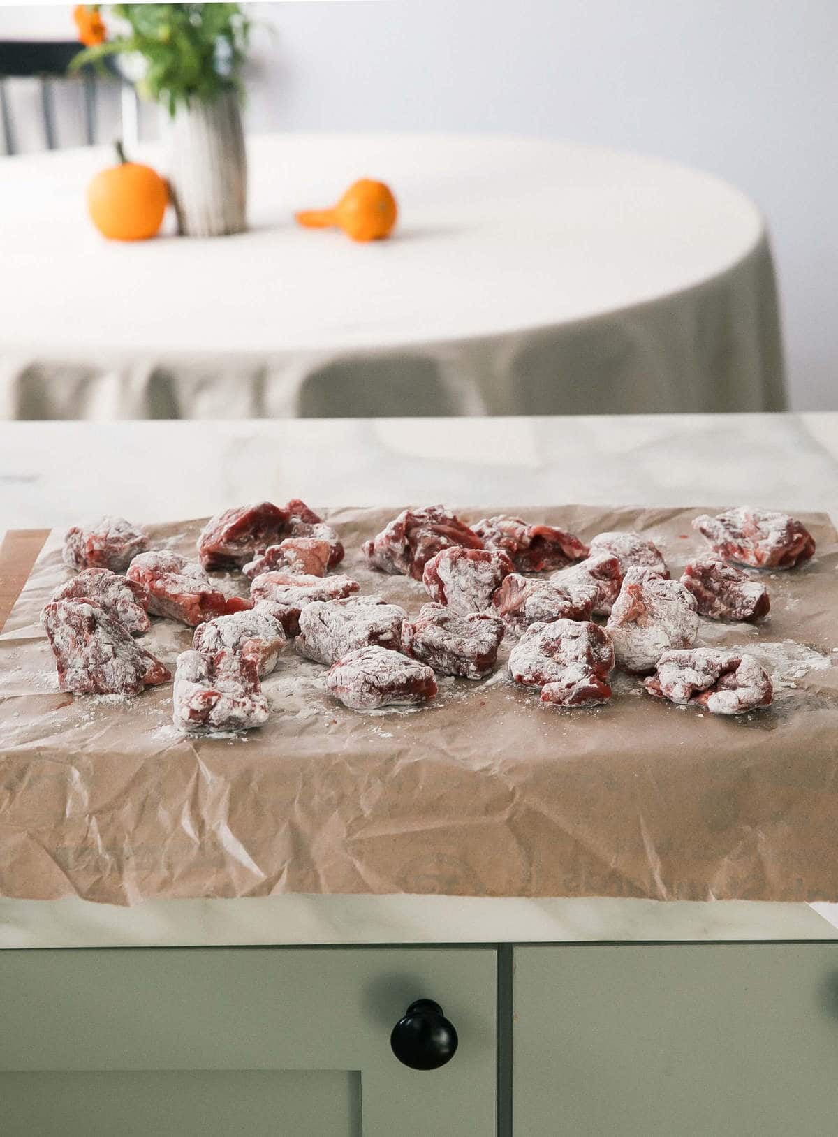 Beef being tossed with flour. 