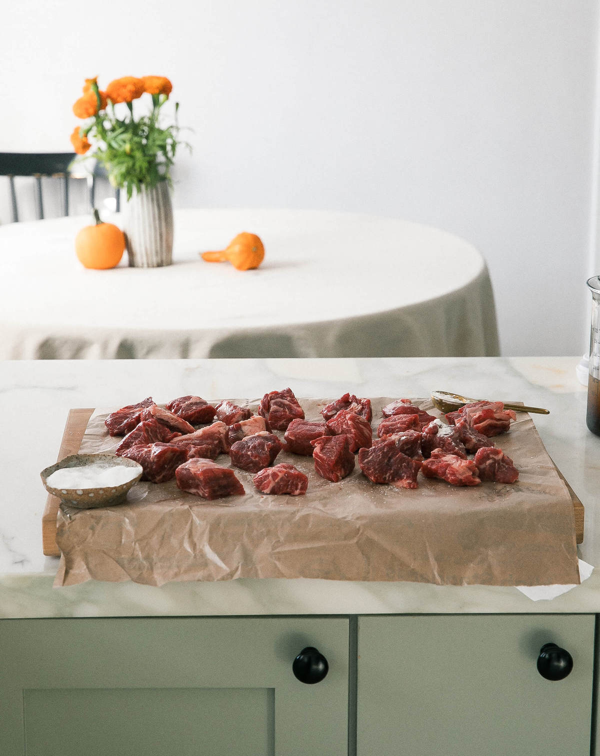 Chuck beef stew meat being salted. 