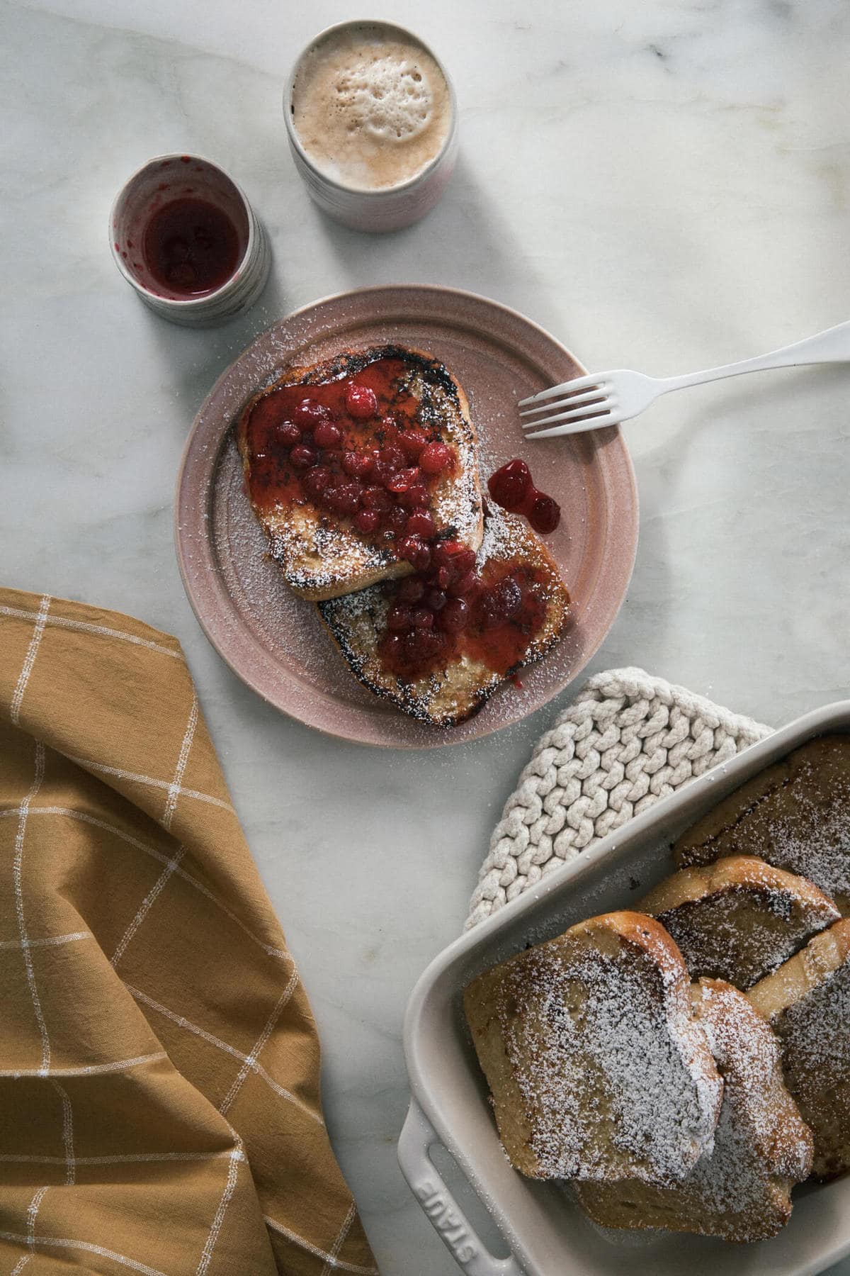 Vegan French Toast on plate with coffee and cranberry sauce on top. 