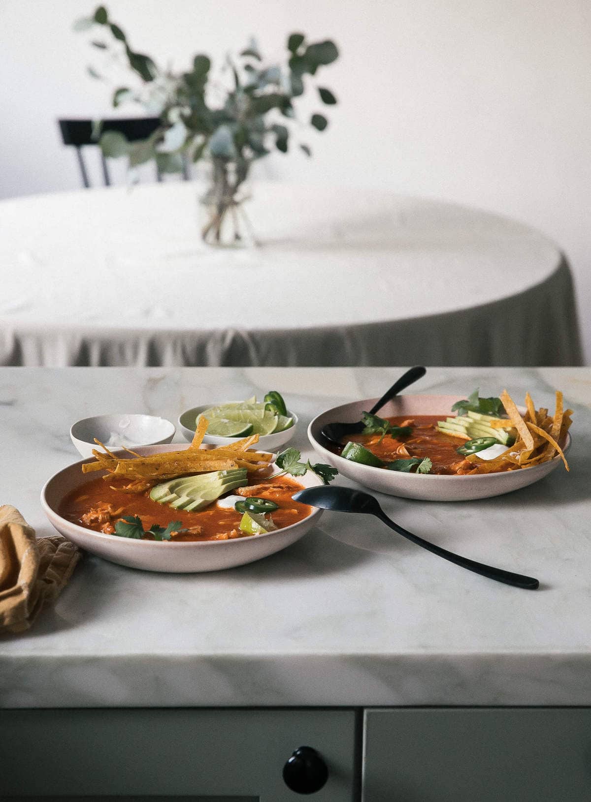 Bowls of instant pot chicken tortilla soup on a counter.