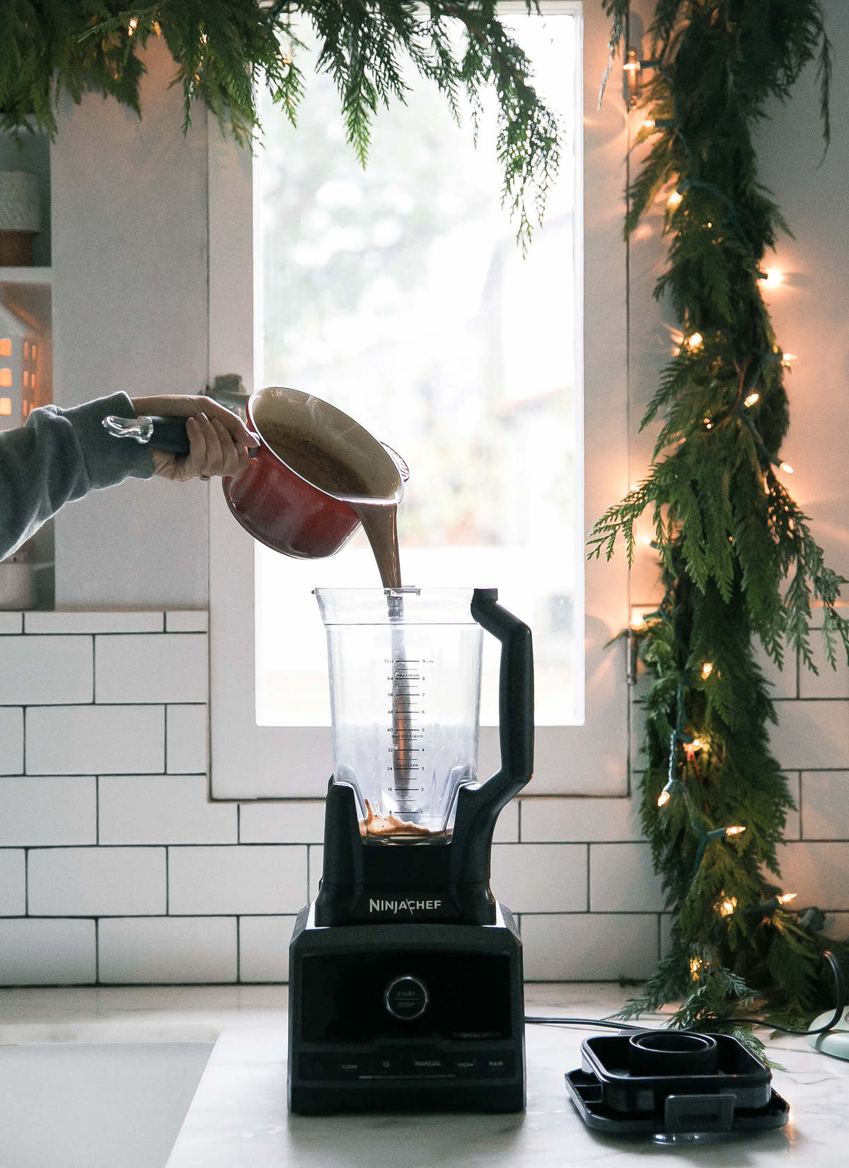 Oat milk hot chocolate being poured into a blender. 