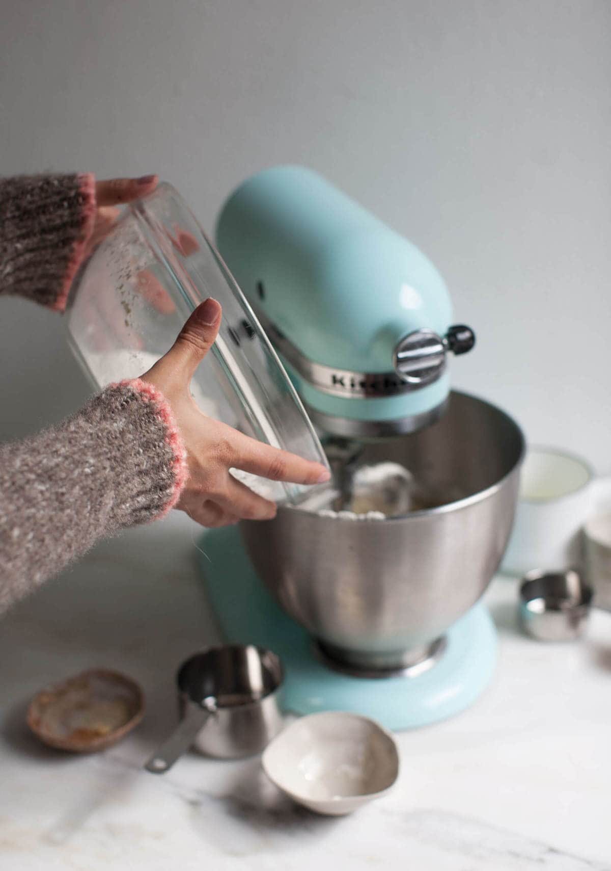 Flour being added to a mixer. 