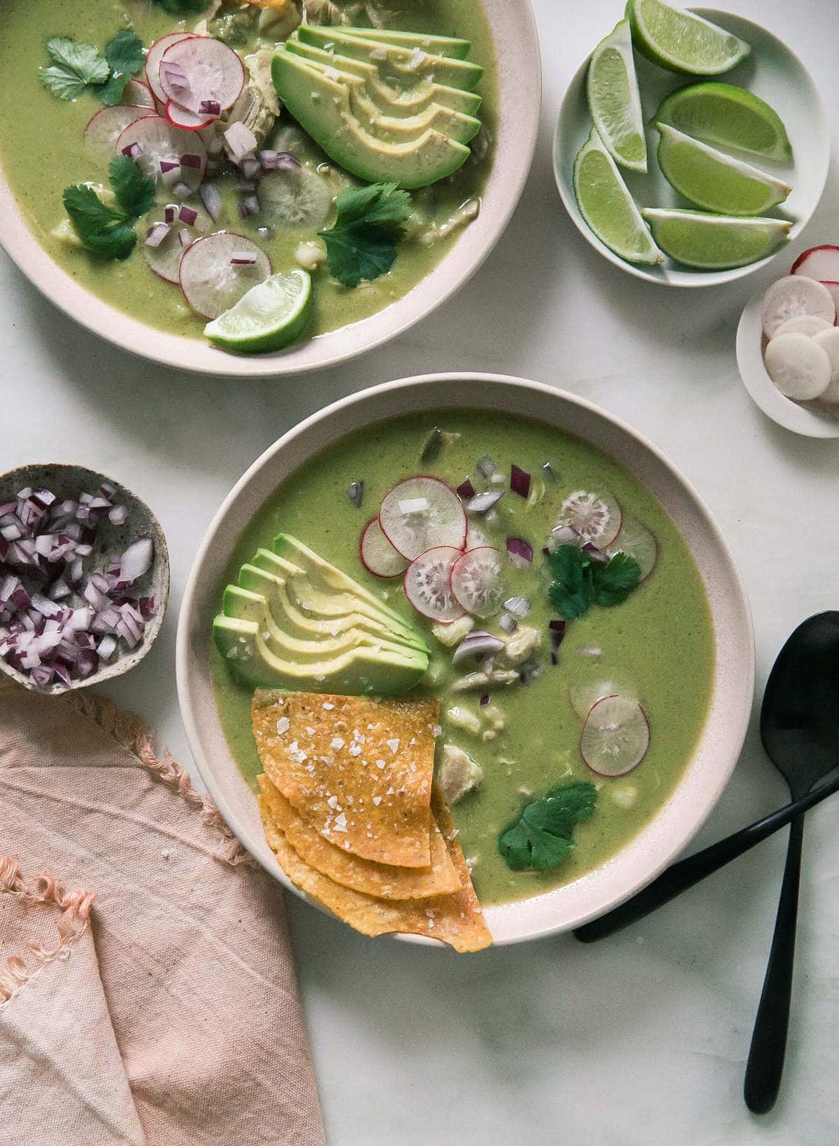 Pozole Verde in bowls with garnishes. 