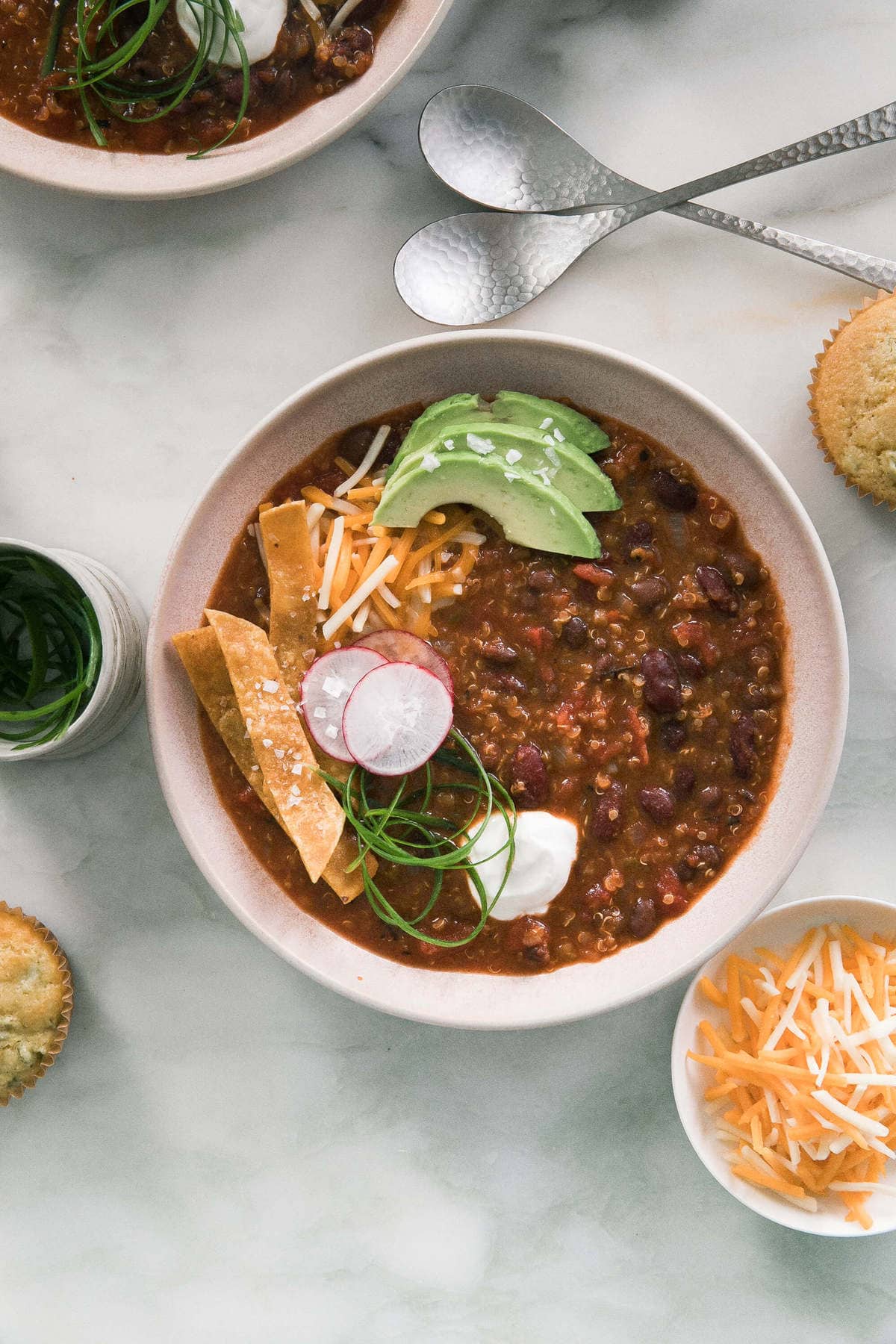 Instant Pot Vegan Chili in bowls with chips, radishes and sour cream on top. 