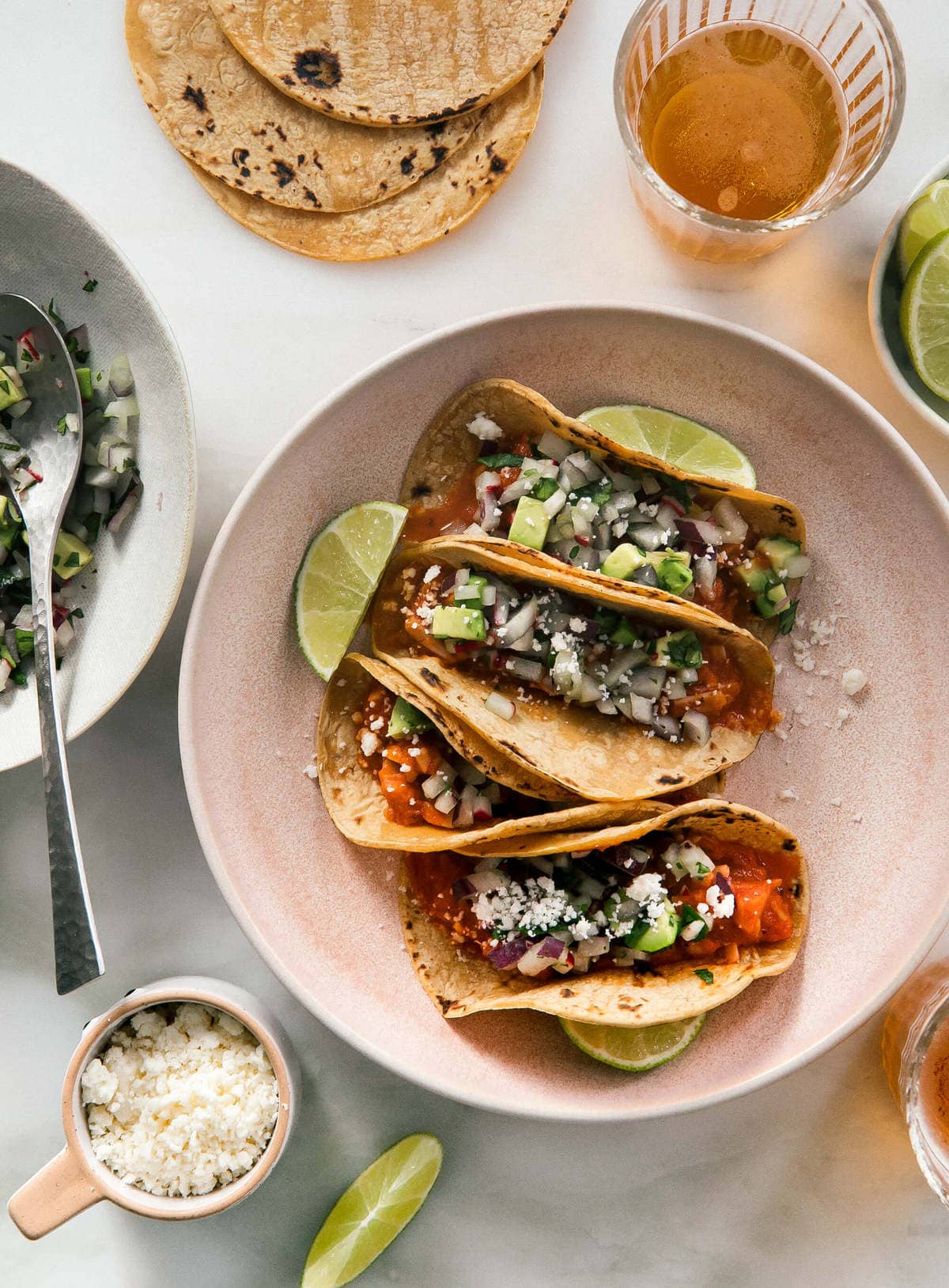 Jackfruit tinga tacos on a plate with lime wedges.