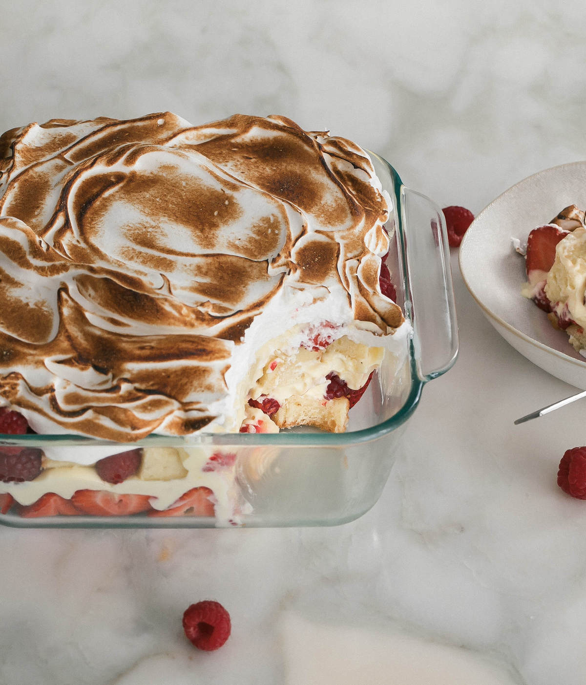 Lemon Berry Meringue Trifle in a pan with a spoonful missing. 
