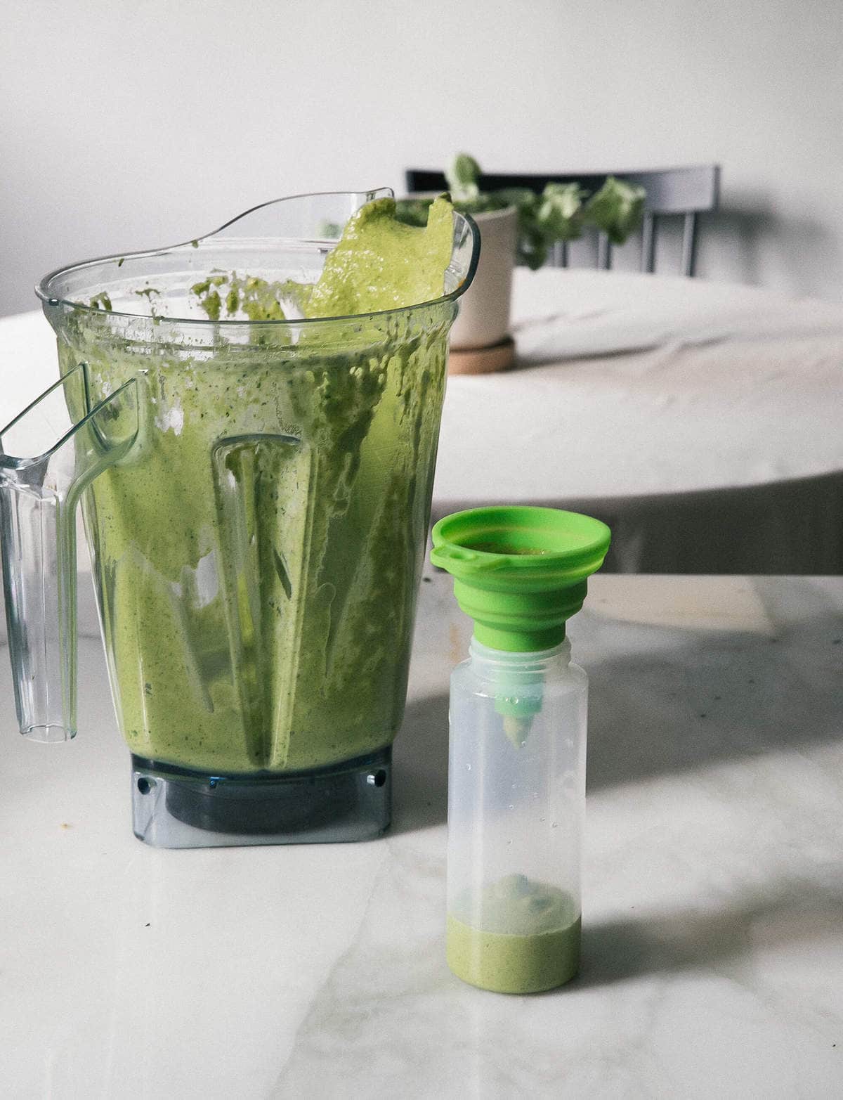 Aji Verde (Peruvian Green Sauce) being transferred to a plastic bottle. 