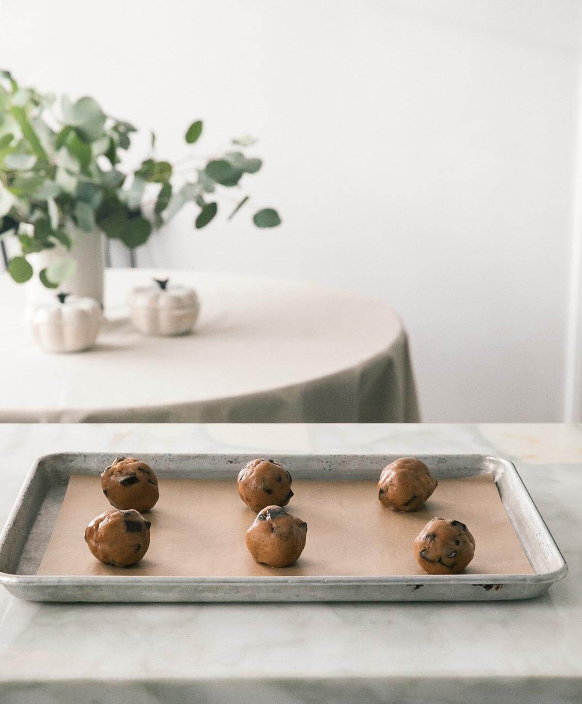 raw cookie dough balls on a baking sheet