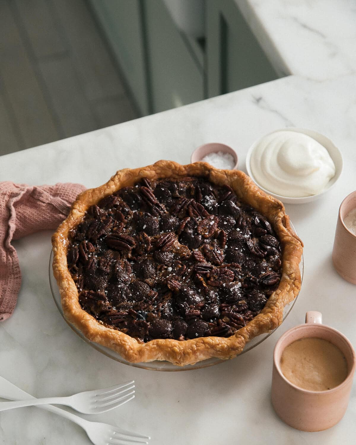 Dark Chocolate Pecan Pie with coffee around it. 