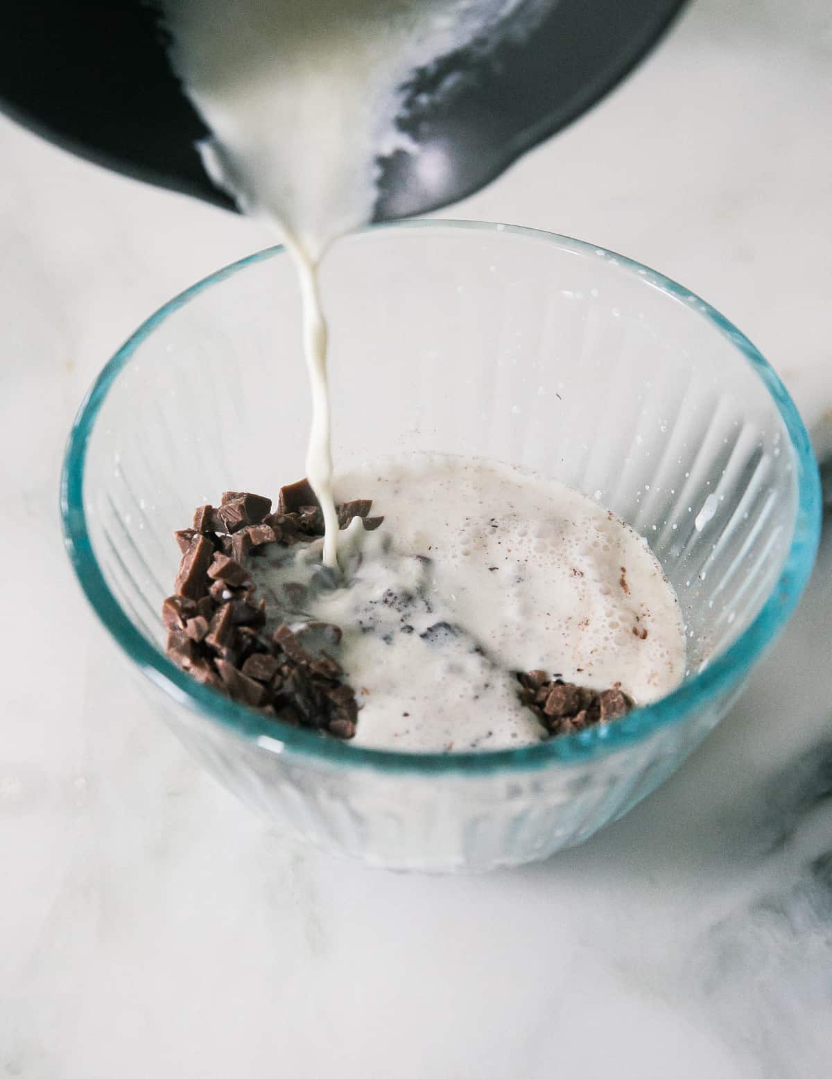 Heavy cream being added to chocolate. 