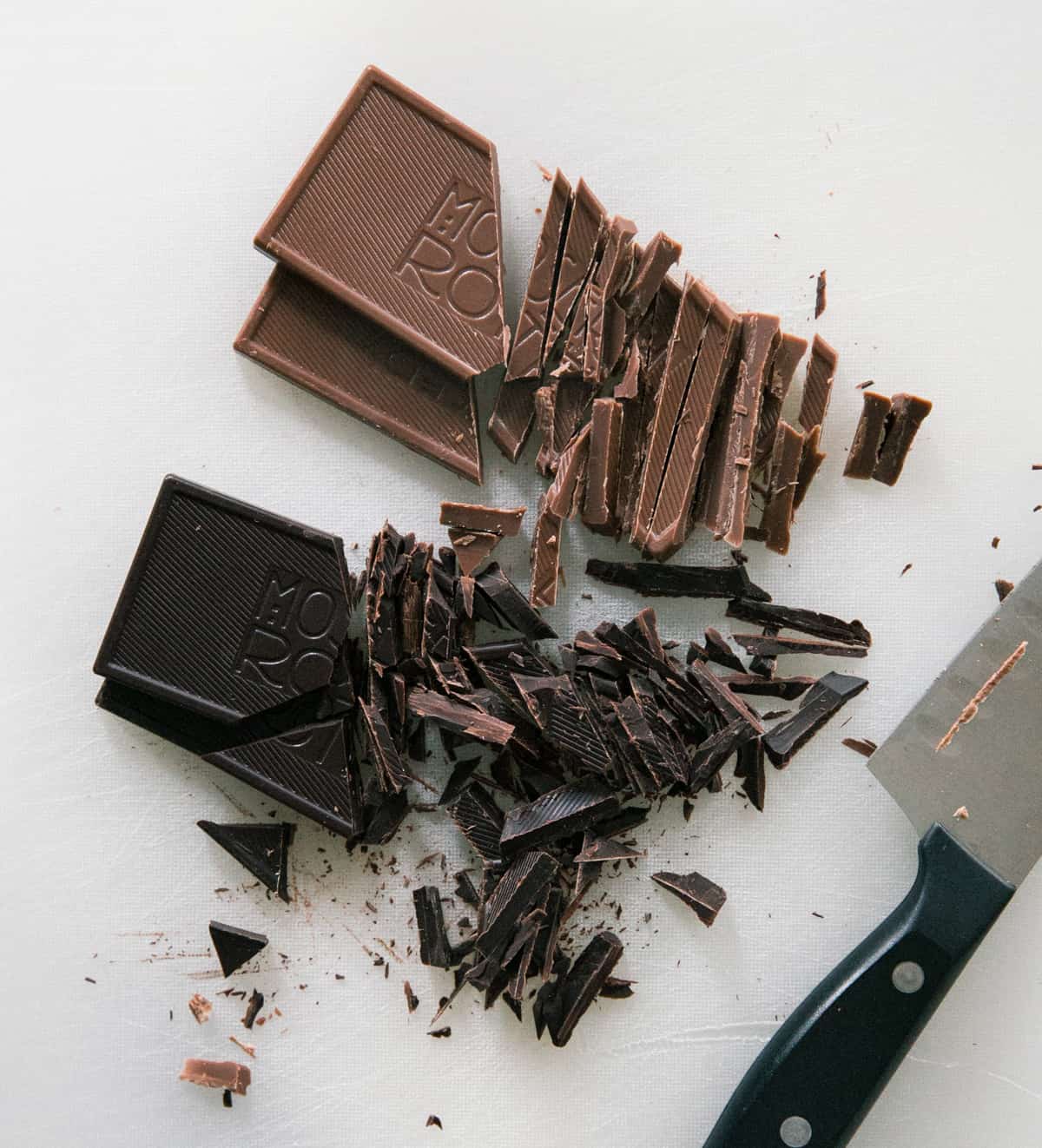 Chocolate chopped on a cutting board. 