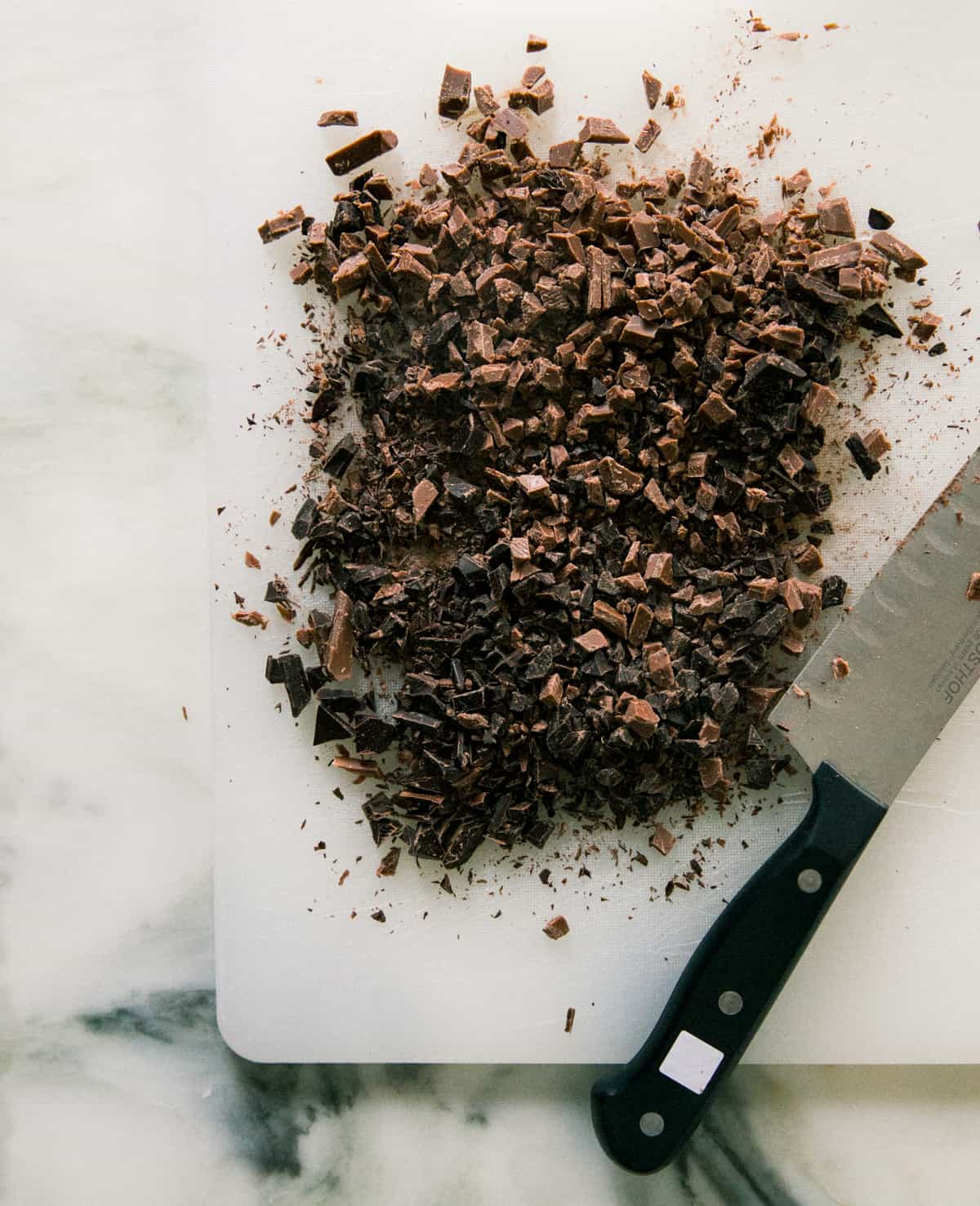 Chocolate chopped on a cutting board. 