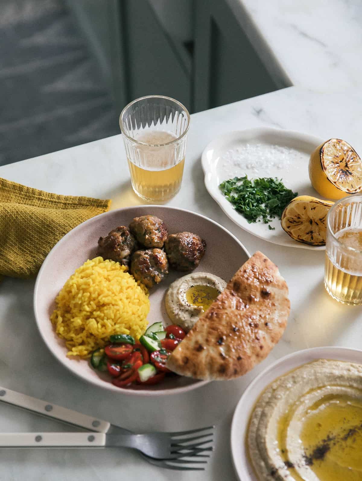 Lamb Kofta in a bowl with hummus, salad and rice. 