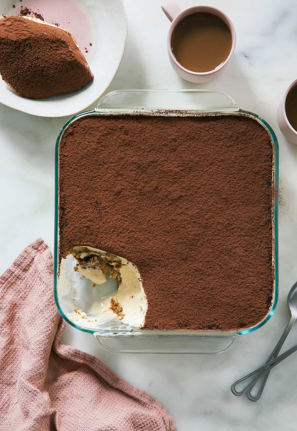 Whole tiramisu dish with a scoop taken out. 