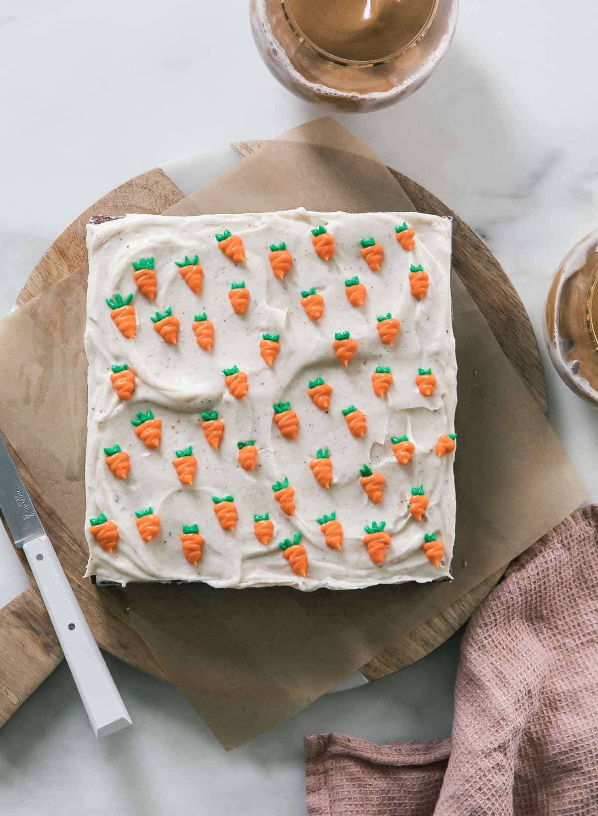 Mini Carrot Cake with Brown Butter Cream Cheese Frosting on a round board with a knife. 