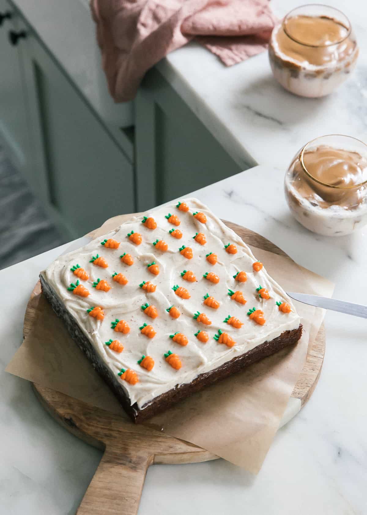 Mini Carrot Cake with Brown Butter Cream Cheese Frosting on a round board with a knife. 