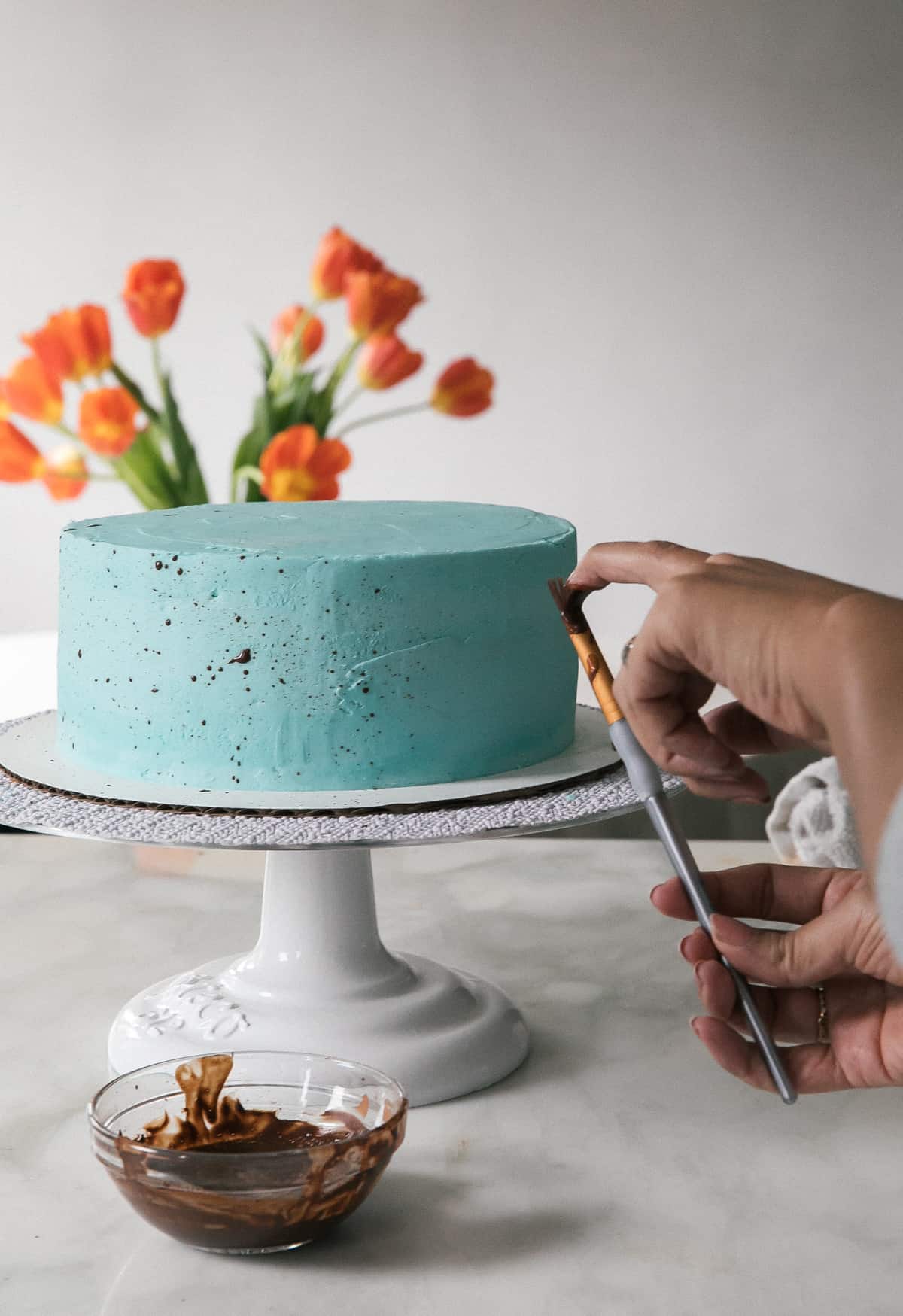 Speckled Egg Cake with tulips on table. 