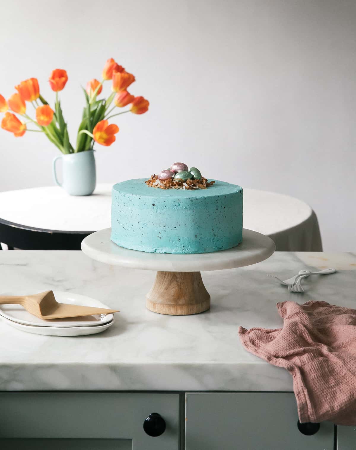 Speckled Egg Cake with tulips on table. 