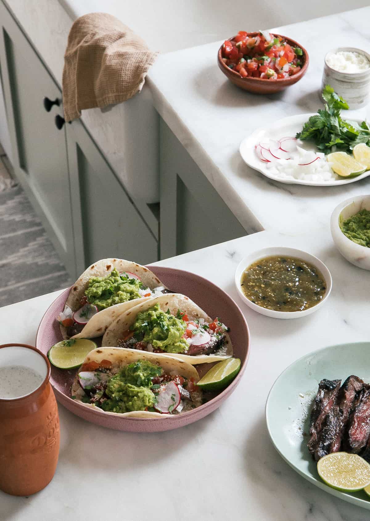 Carne Asada Tacos with salsas, beer, guacamole all around. 