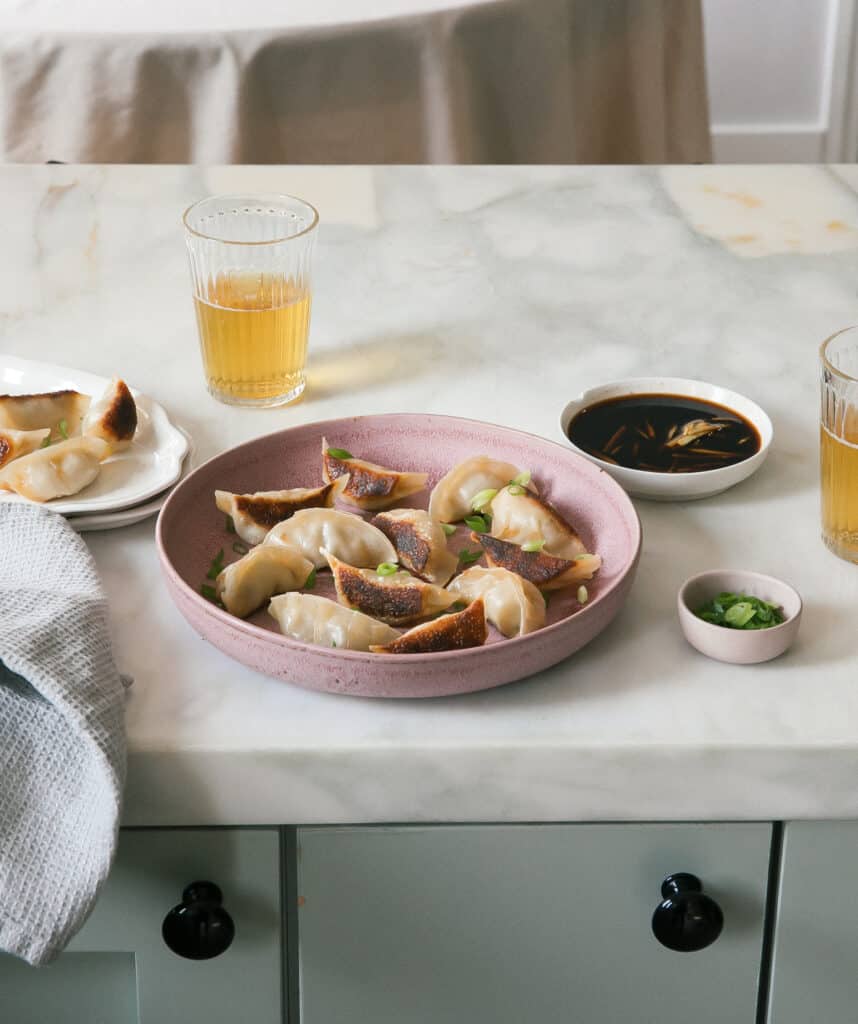 Potstickers on a plate with beer and dipping sauce