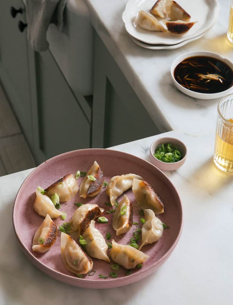 Potstickers on a plate with beer and dipping sauce
