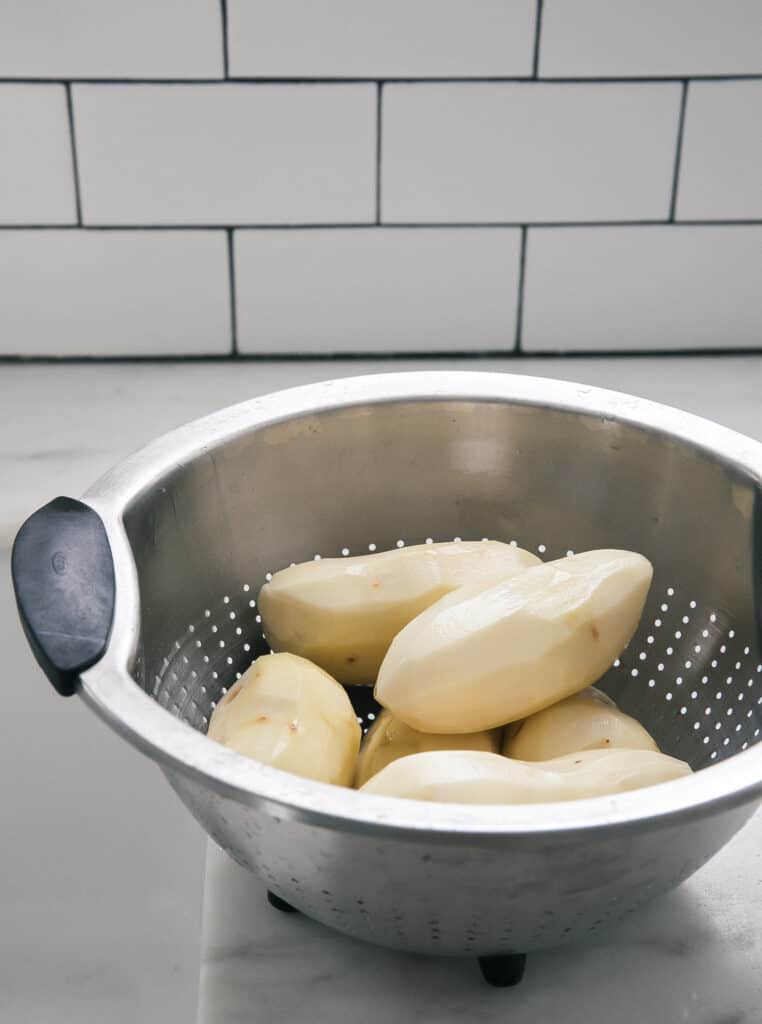Raw potatoes in a colander. 