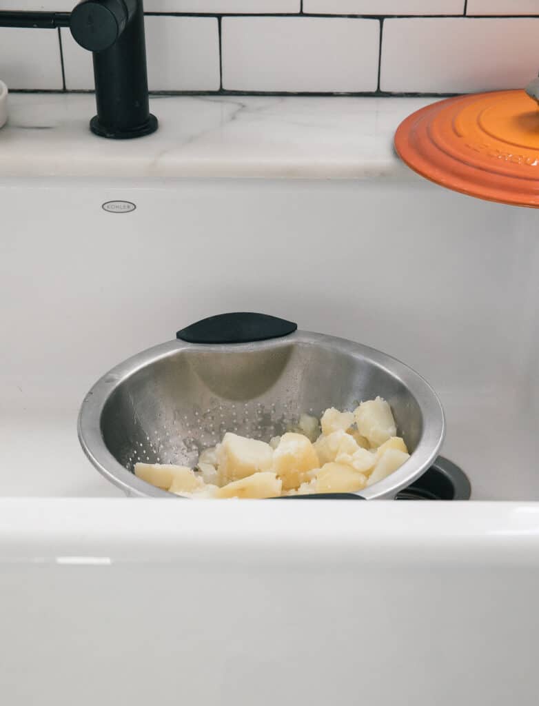 Potatoes in a colander in the sink.