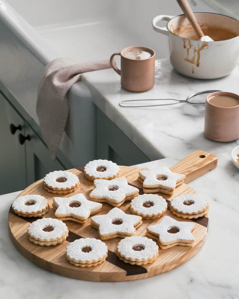 Salted Caramel Linzer Cookies on Counter with mugs