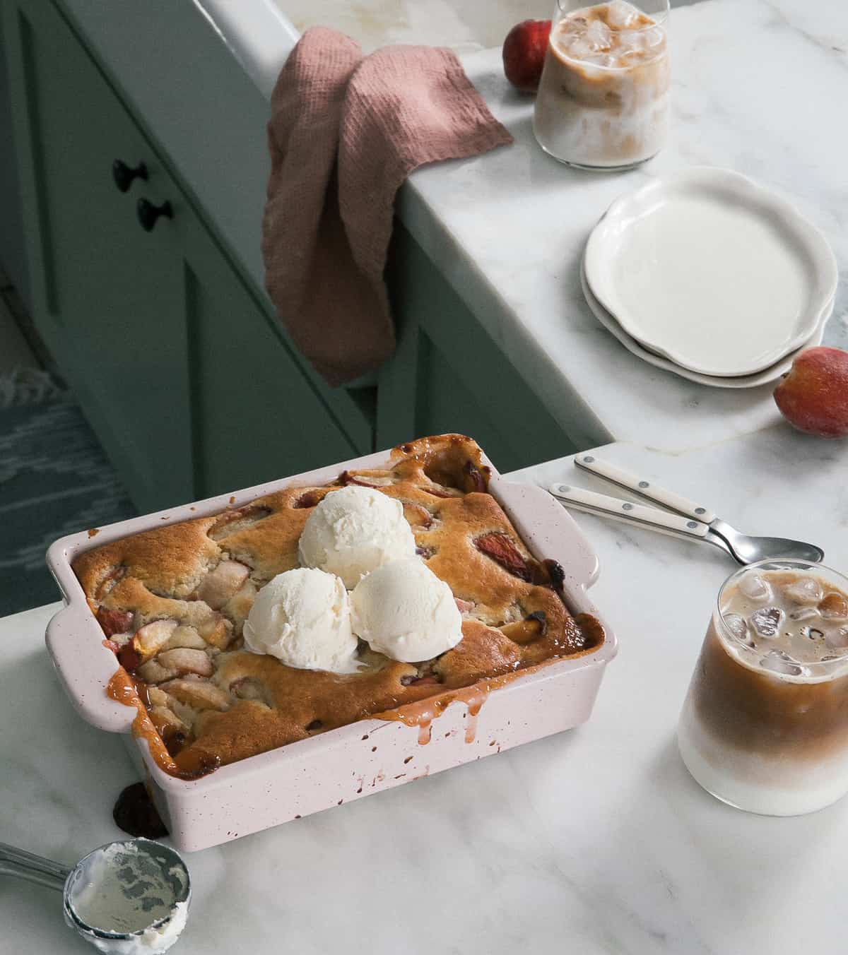 Easy Peach Cobbler in baking dish with ice cream. 