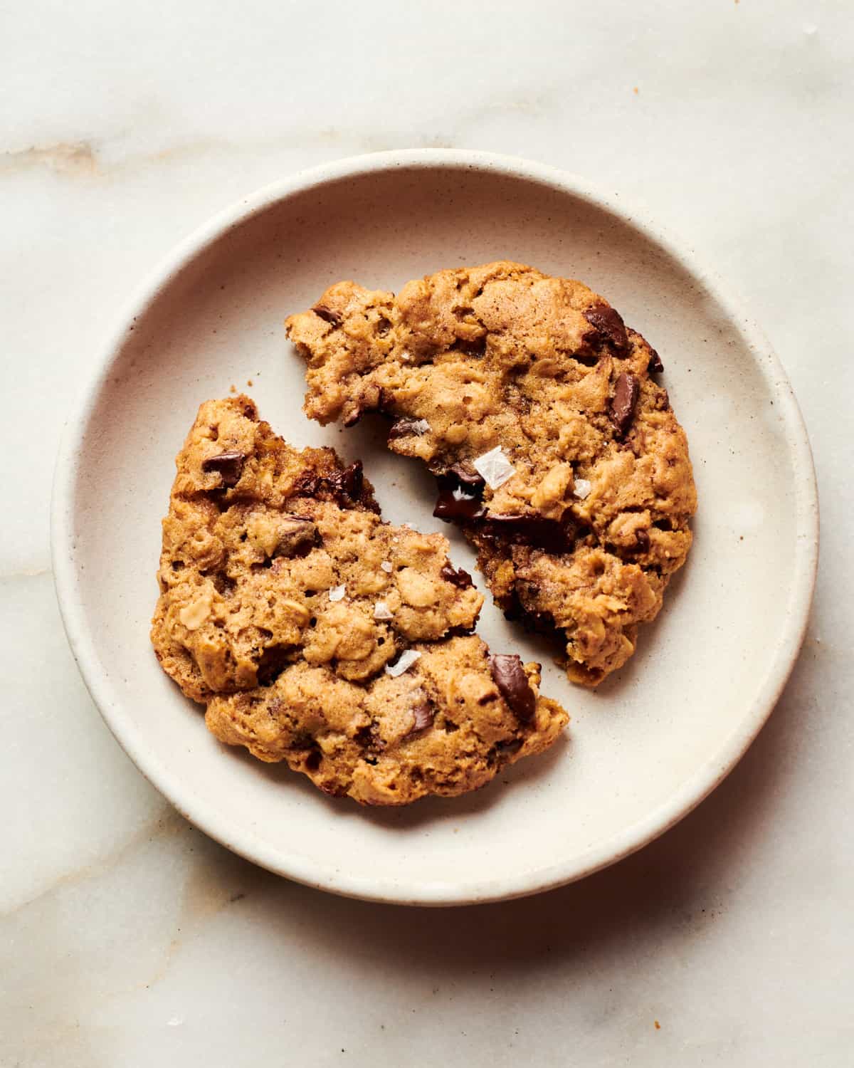 Oatmeal Chocolate Chip Cookies on on plate with flakey sea salt. 