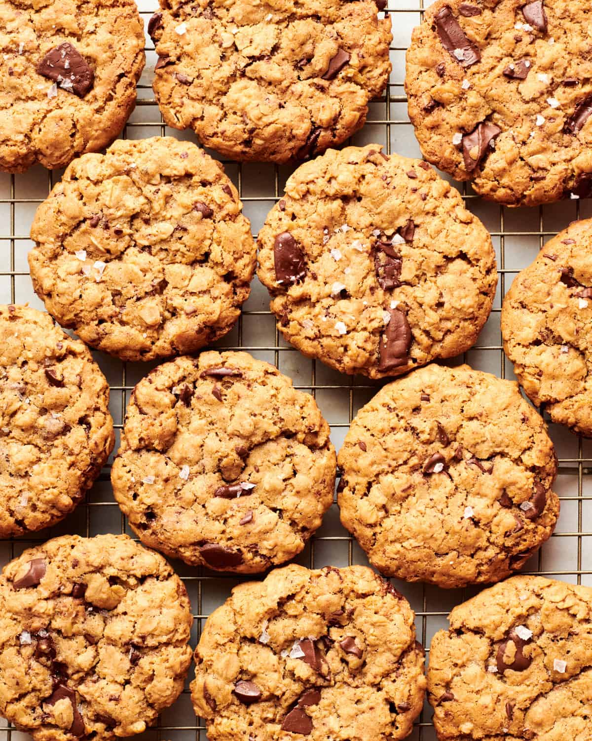 Oatmeal Chocolate Chip Cookies on on cooling rack with flakey sea salt. 