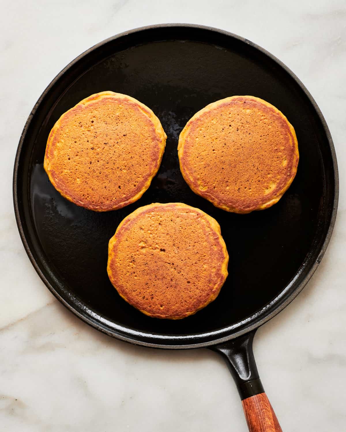 Pumpkin pancakes in a skillet.