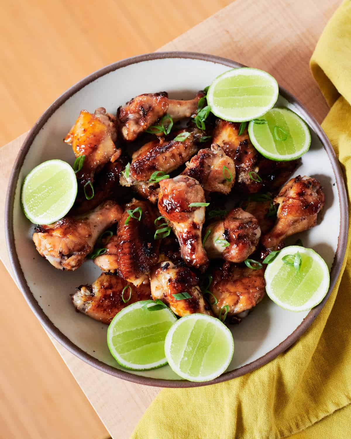 Garlic Chicken Wings in a bowl with limes. 