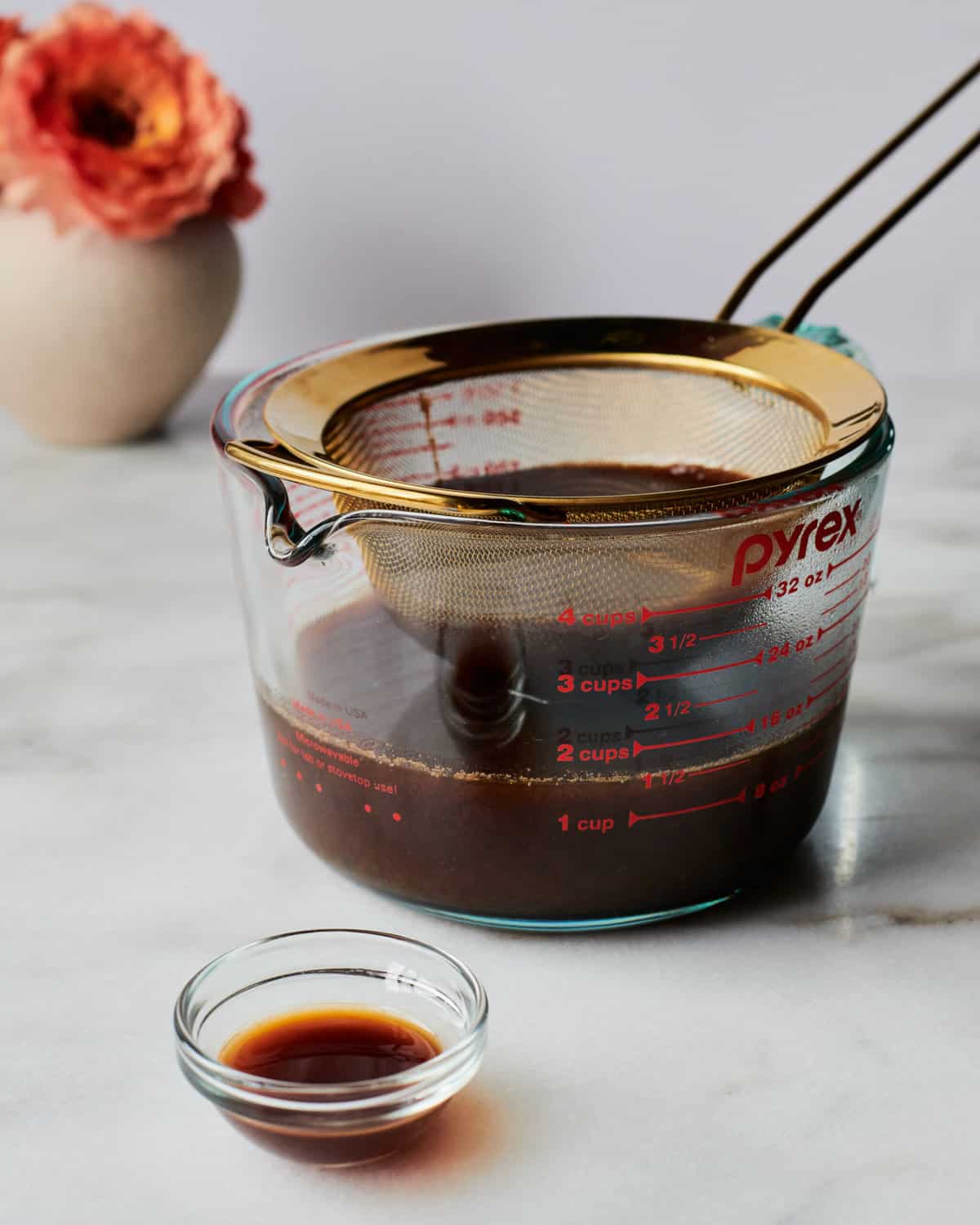 Straight on photo of syrup being strained into measuring cup