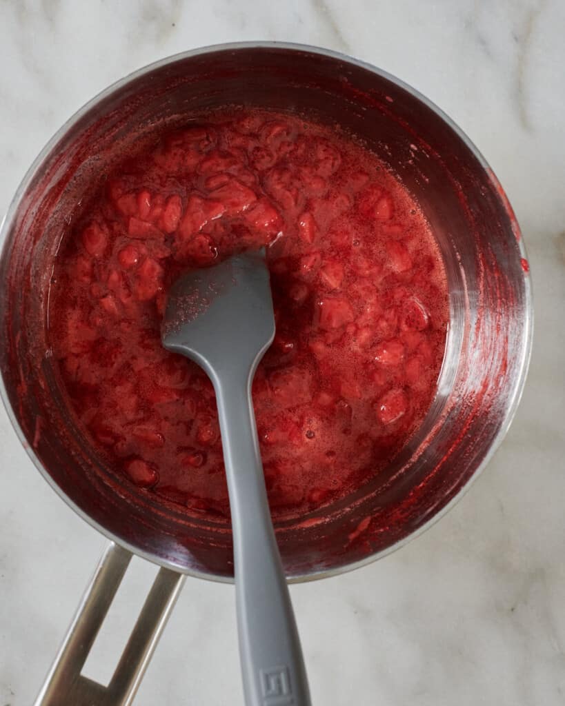 Strawberry syrup being cooked in a pan