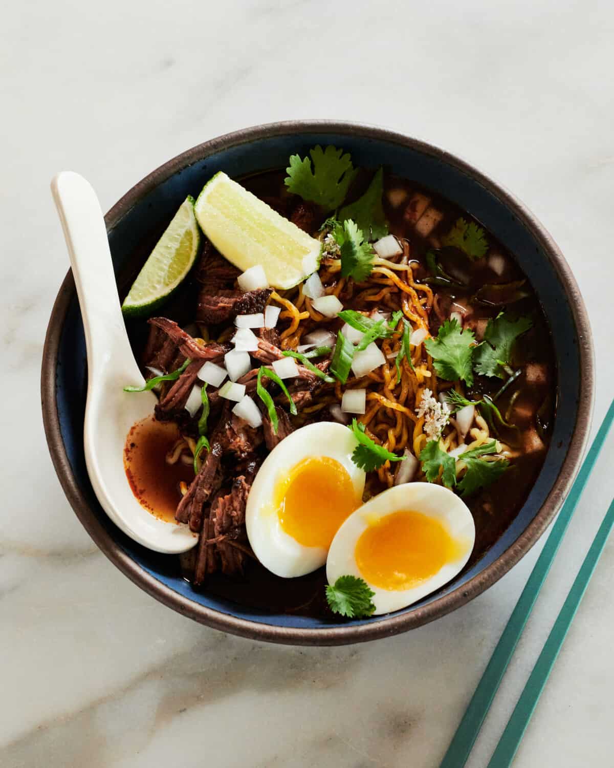 Birria Ramen recipe in bowl with chopsticks on the side. 